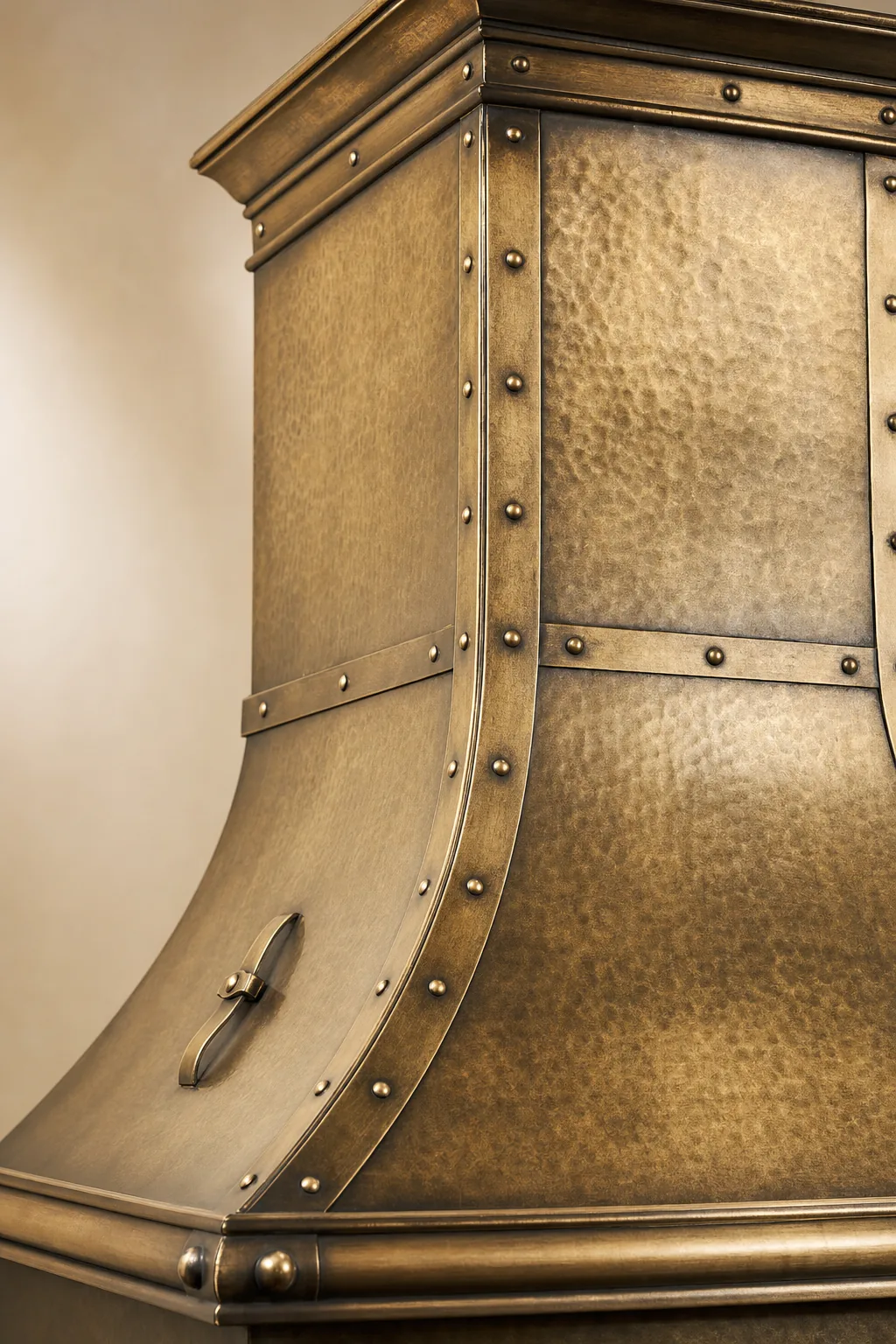 Hand-hammered antique brass range hood with rivet detail