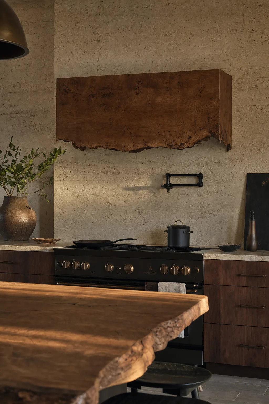 Live-edge English brown oak slab wrapping a bespoke range hood in an organic-modern kitchen